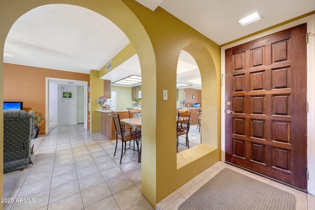 foyer entrance with light tile patterned floors and visible vents