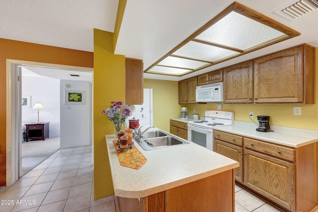 kitchen with white appliances, visible vents, light tile patterned flooring, a sink, and light countertops