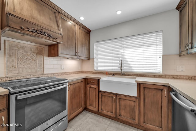 kitchen with custom range hood, sink, decorative backsplash, and appliances with stainless steel finishes