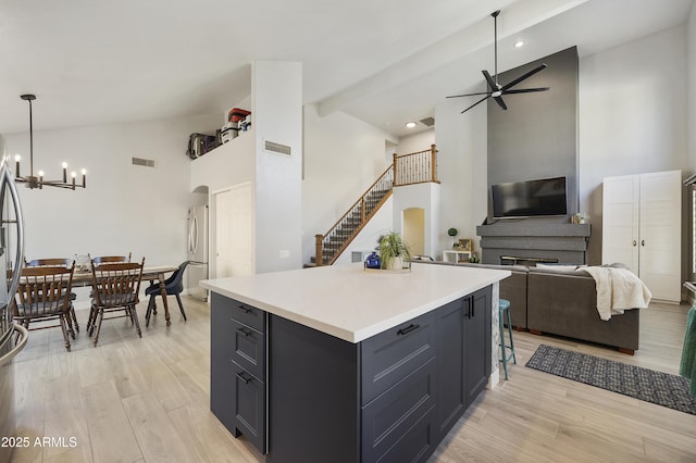 kitchen featuring a center island, pendant lighting, light countertops, freestanding refrigerator, and open floor plan