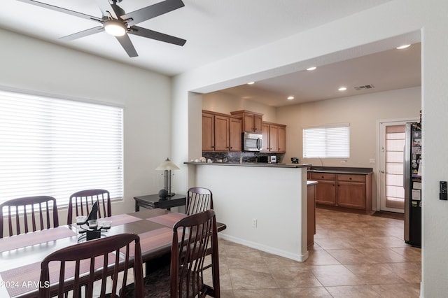 dining room with ceiling fan, a healthy amount of sunlight, and light tile patterned floors