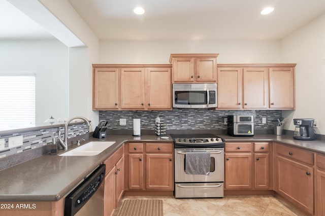 kitchen with decorative backsplash, appliances with stainless steel finishes, light tile patterned floors, and sink