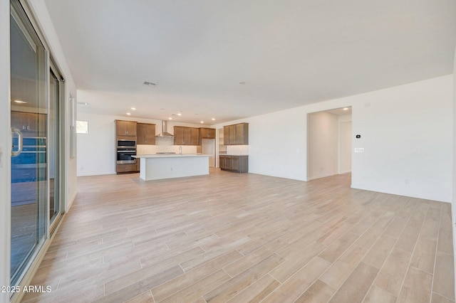 unfurnished living room featuring visible vents, recessed lighting, and light wood-type flooring