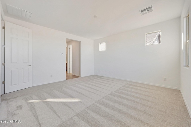 carpeted spare room with baseboards and visible vents