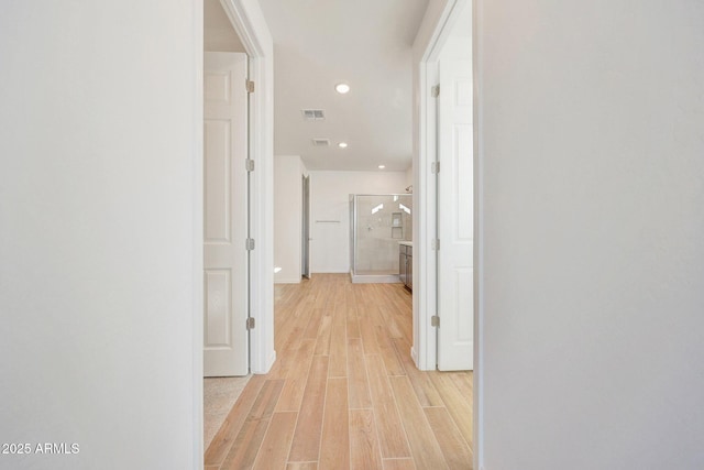 corridor with recessed lighting, light wood-style floors, visible vents, and baseboards