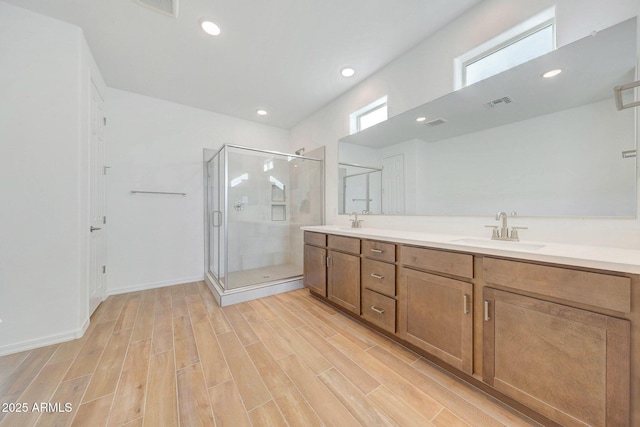 full bath featuring a shower stall, wood tiled floor, and a sink