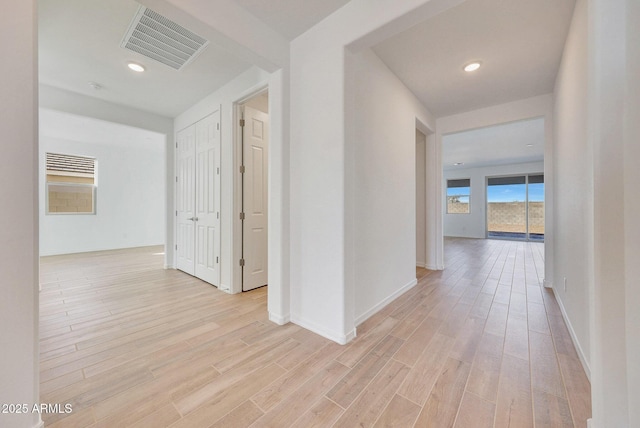 hall with visible vents, recessed lighting, light wood-type flooring, and baseboards