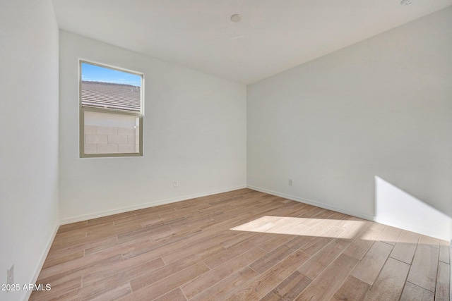 spare room with light wood-style flooring and baseboards