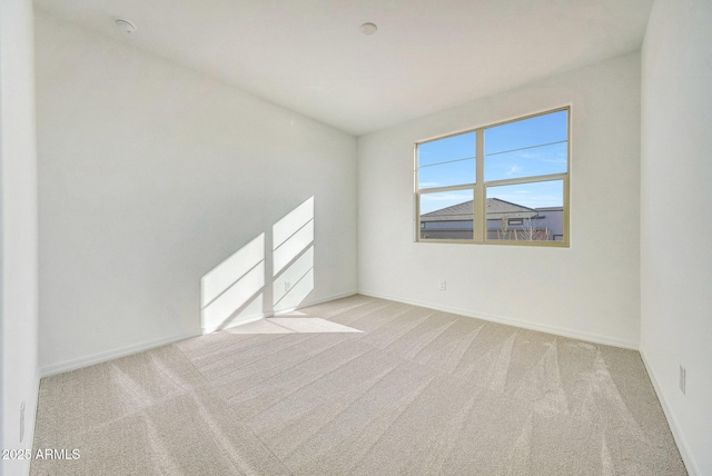 unfurnished room featuring carpet and baseboards