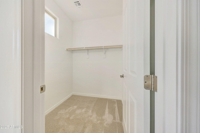 spacious closet with visible vents and light colored carpet