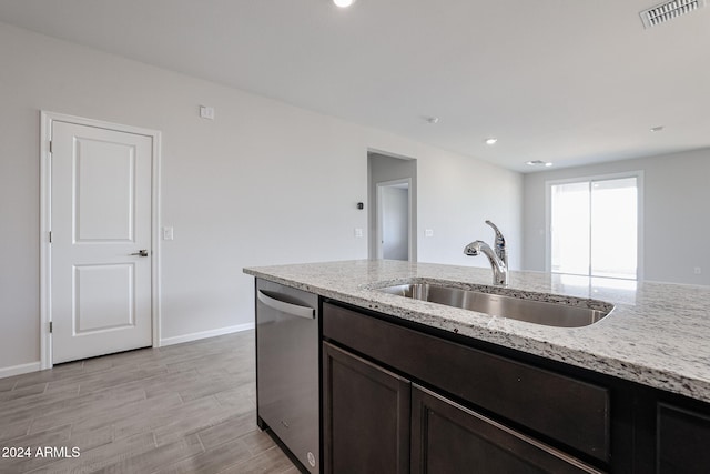 kitchen featuring sink, dark brown cabinets, light hardwood / wood-style floors, stainless steel dishwasher, and light stone counters