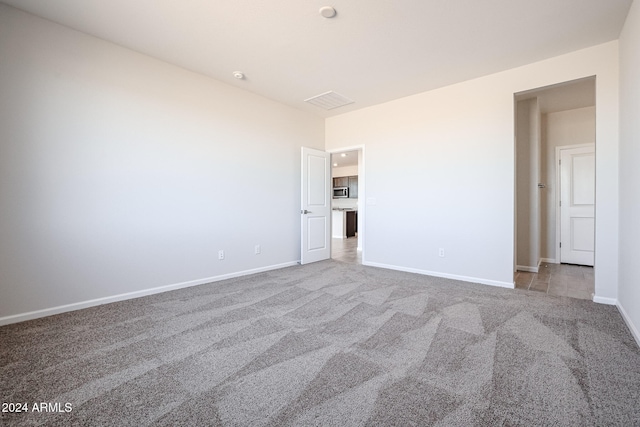 unfurnished room featuring light colored carpet