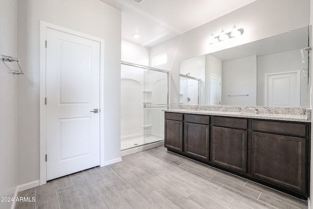 bathroom featuring vanity, an enclosed shower, and hardwood / wood-style flooring