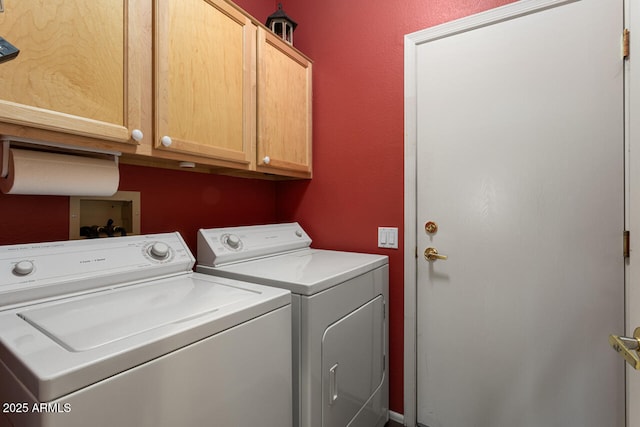 clothes washing area featuring cabinets and washer and dryer