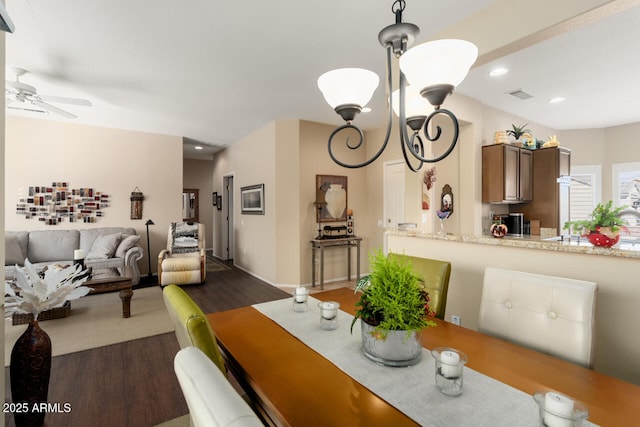 dining area featuring ceiling fan with notable chandelier and hardwood / wood-style floors