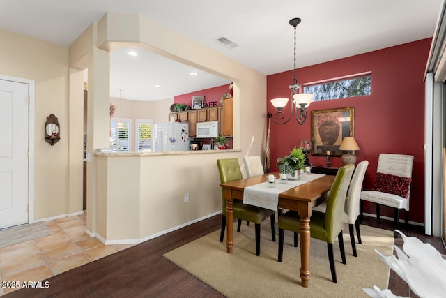 dining room with a notable chandelier and light hardwood / wood-style flooring