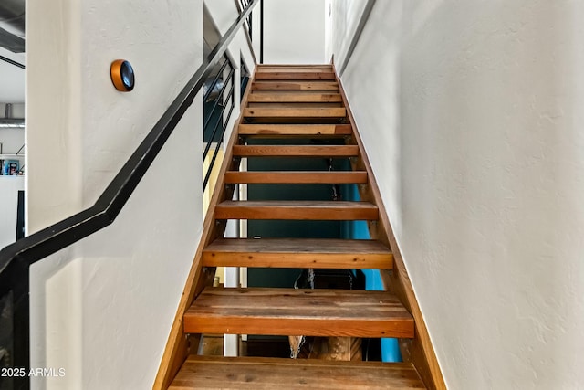 stairway featuring a textured wall