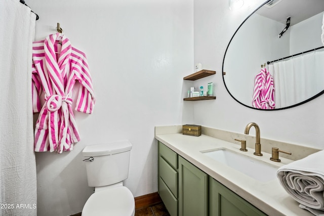 full bath featuring toilet, vanity, and baseboards