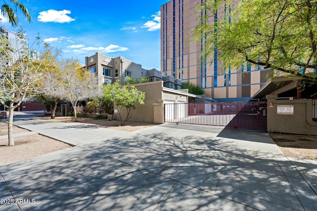 view of road featuring driveway and a gate