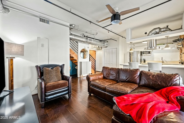 living area featuring visible vents, wood-type flooring, ceiling fan, and stairs