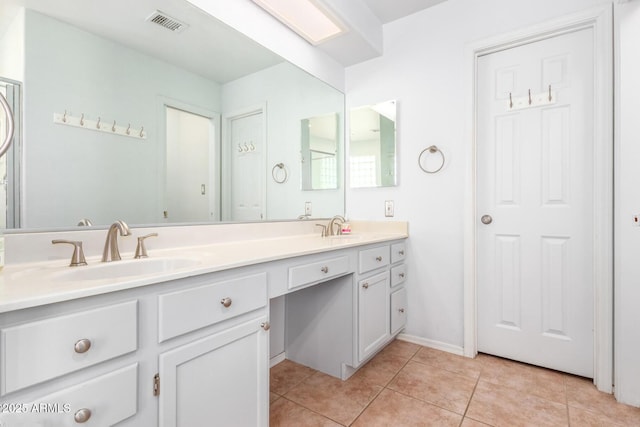 full bathroom featuring tile patterned flooring, visible vents, a sink, and double vanity