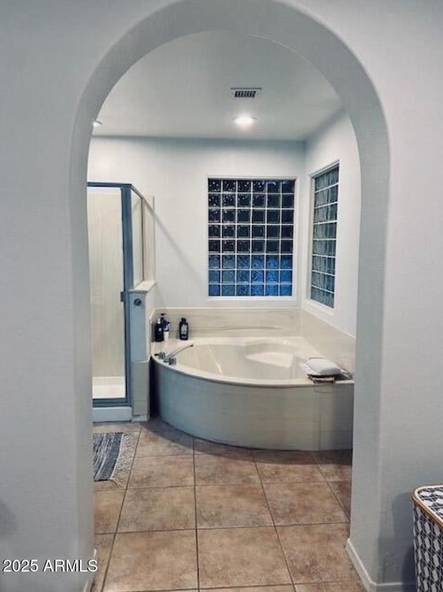 full bathroom with a stall shower, tile patterned flooring, and a bath