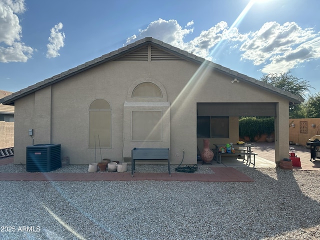 rear view of house with central AC and a patio