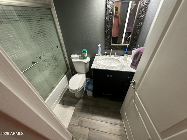 full bathroom featuring shower / bath combination with glass door, vanity, and toilet