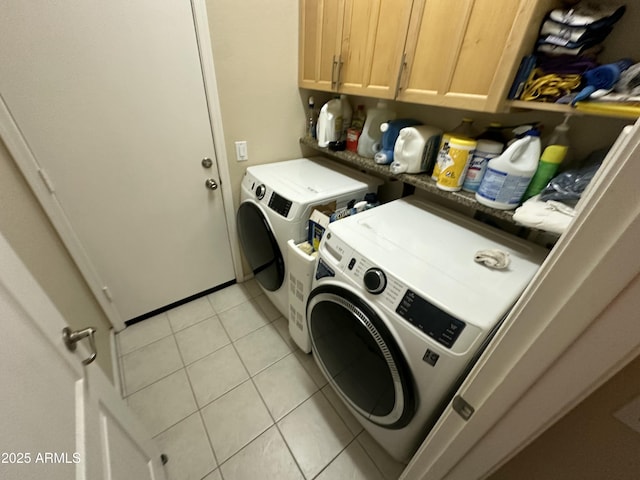 clothes washing area featuring cabinets, light tile patterned floors, and independent washer and dryer