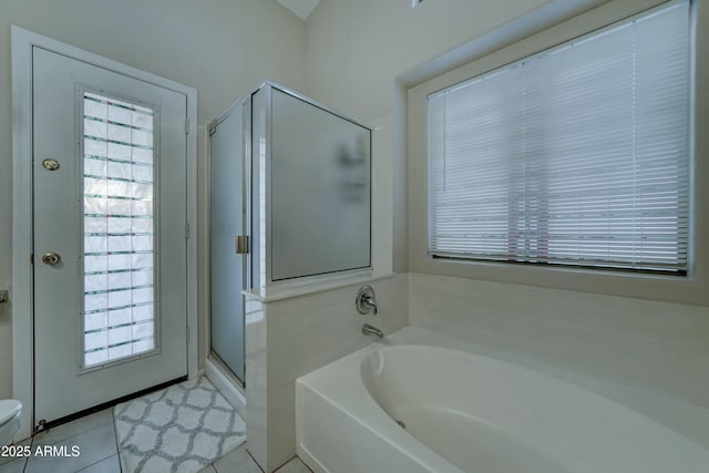 bathroom with tile patterned flooring and separate shower and tub