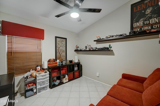 living area with ceiling fan, lofted ceiling, and light tile patterned floors