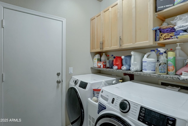 washroom with cabinets and washer and clothes dryer