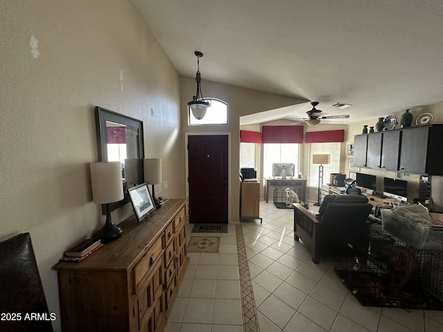 tiled living room with ceiling fan and vaulted ceiling