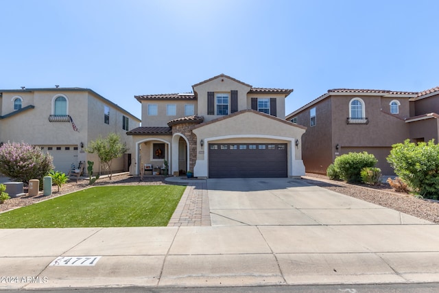 mediterranean / spanish-style home featuring central AC unit, a front yard, and a garage