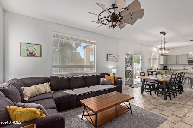 living room featuring ceiling fan with notable chandelier