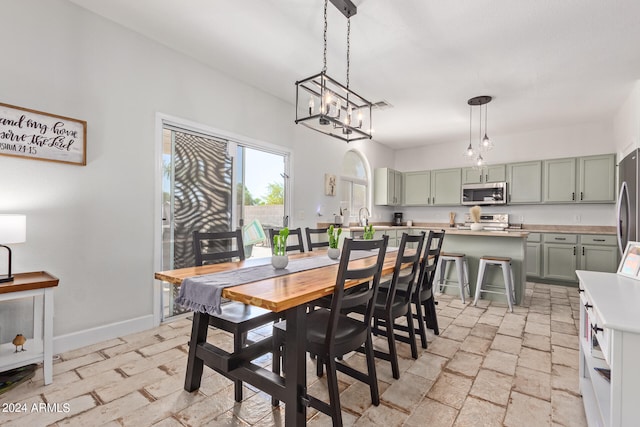 dining room with sink and a notable chandelier