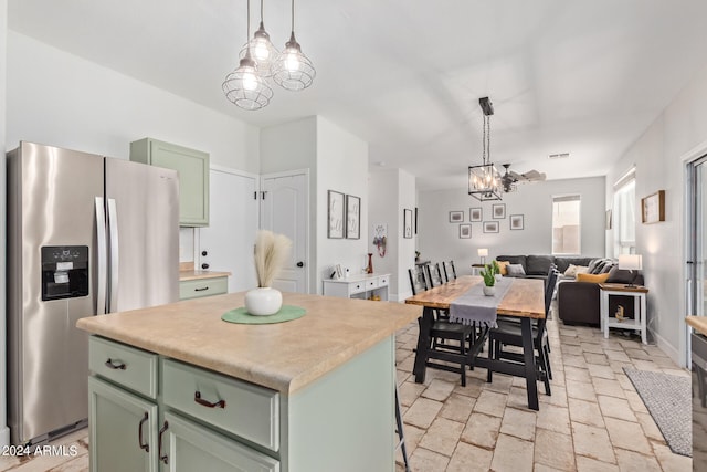 kitchen featuring decorative light fixtures, a center island, stainless steel fridge with ice dispenser, and green cabinets