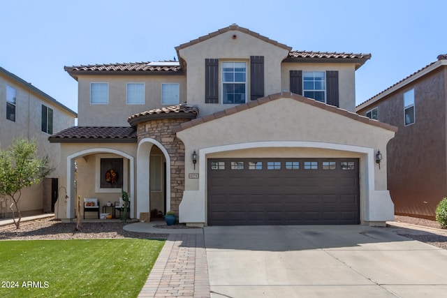 mediterranean / spanish-style home with a garage and a front yard