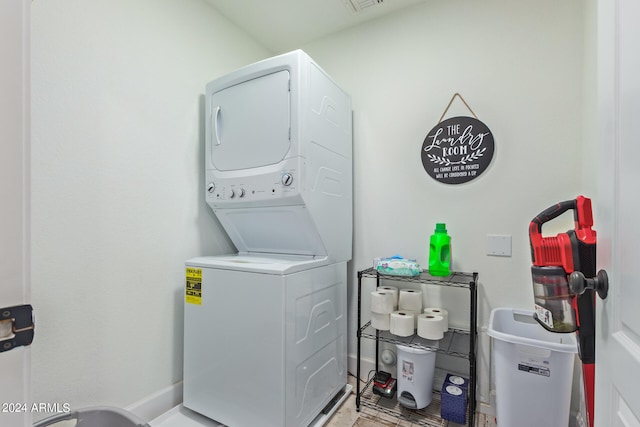 clothes washing area featuring stacked washer / dryer