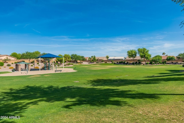 view of home's community featuring a playground and a lawn