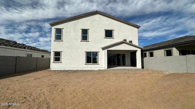 rear view of house featuring a patio area, a fenced backyard, and stucco siding