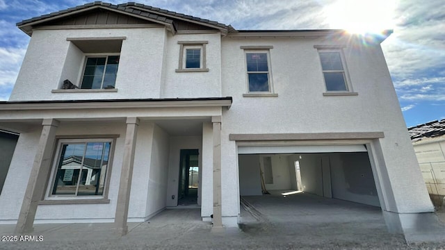 view of front of property featuring stucco siding, a garage, and a tiled roof