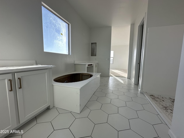 full bathroom with a healthy amount of sunlight, vanity, and a tub to relax in