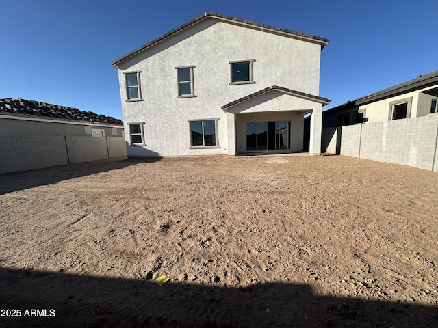 back of property featuring a fenced backyard and stucco siding