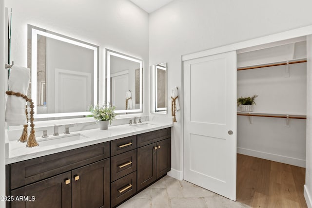 19550 N Grayhawk Dr Unit 1144, Scottsdale, AZ 85255 - bathroom featuring double vanity, a spacious closet, and wood finished floors