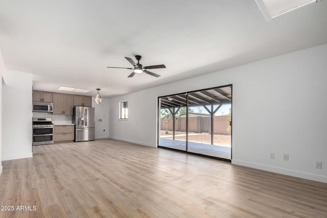 3802 N 48th Dr, Phoenix, AZ 85031 - unfurnished living room with baseboards, ceiling fan, and light wood-style flooring