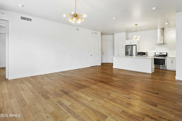 3131 N Central Ave Unit 3009, Phoenix, AZ 85012 - unfurnished living room with wood finished floors, a chandelier, and baseboards