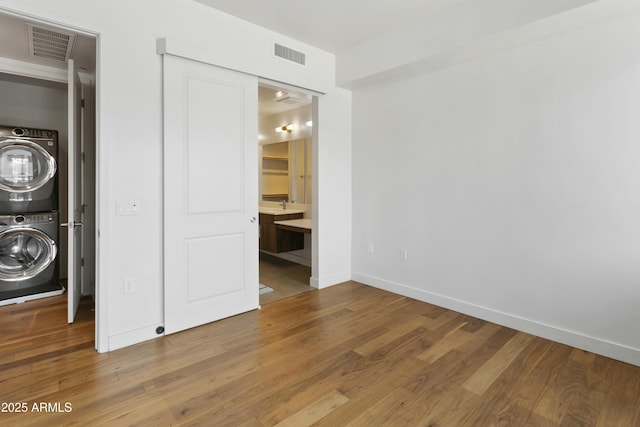 3131 N Central Ave Unit 3009, Phoenix, AZ 85012 - laundry area with stacked washer / drying machine, wood finished floors, and baseboards