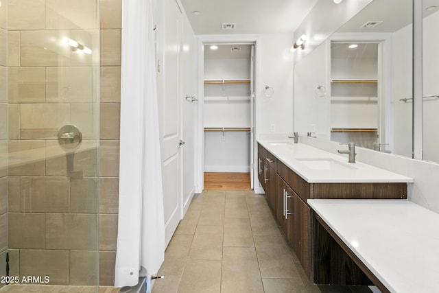 3131 N Central Ave Unit 3009, Phoenix, AZ 85012 - full bathroom with a spacious closet, double vanity, tile patterned flooring, and tiled shower