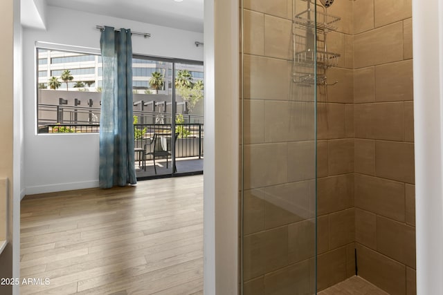 3131 N Central Ave Unit 3009, Phoenix, AZ 85012 - bathroom featuring wood finished floors, a tile shower, and baseboards